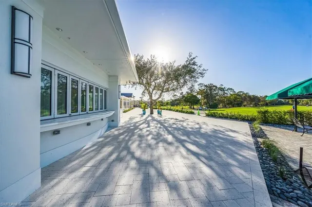 a front view of multi story residential apartment building with yard and palm tree