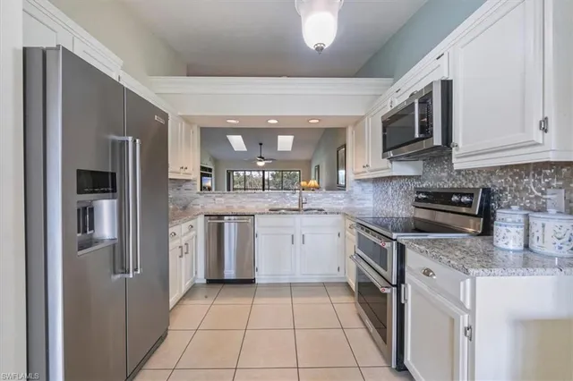 a kitchen with stainless steel appliances granite countertop a refrigerator and a stove top oven