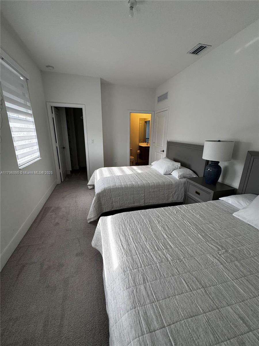 4409 Southwest 173rd Avenue Miramar, FL 33029 - Photo 22 of 38 a bedroom with two beds and a lamp