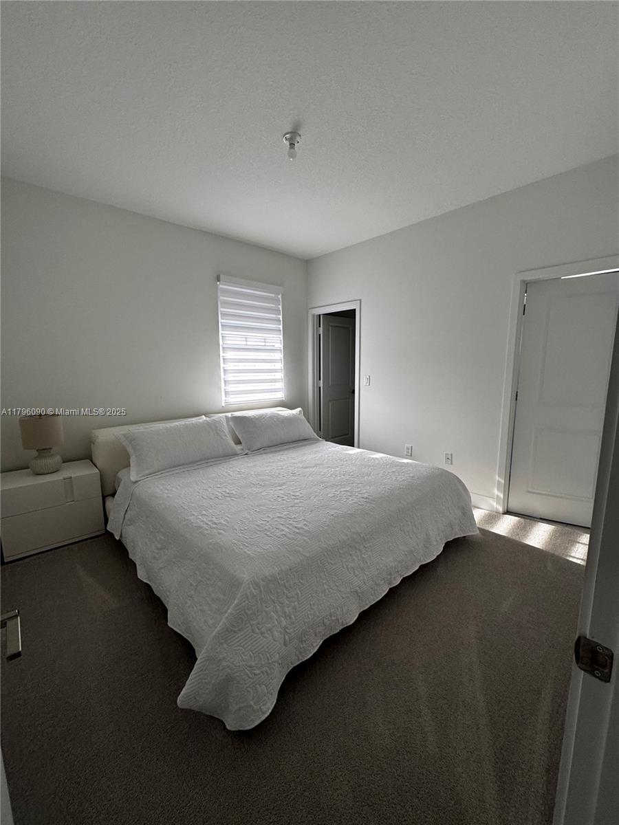4409 Southwest 173rd Avenue Miramar, FL 33029 - Photo 25 of 38 a bedroom with a bed and a night stand