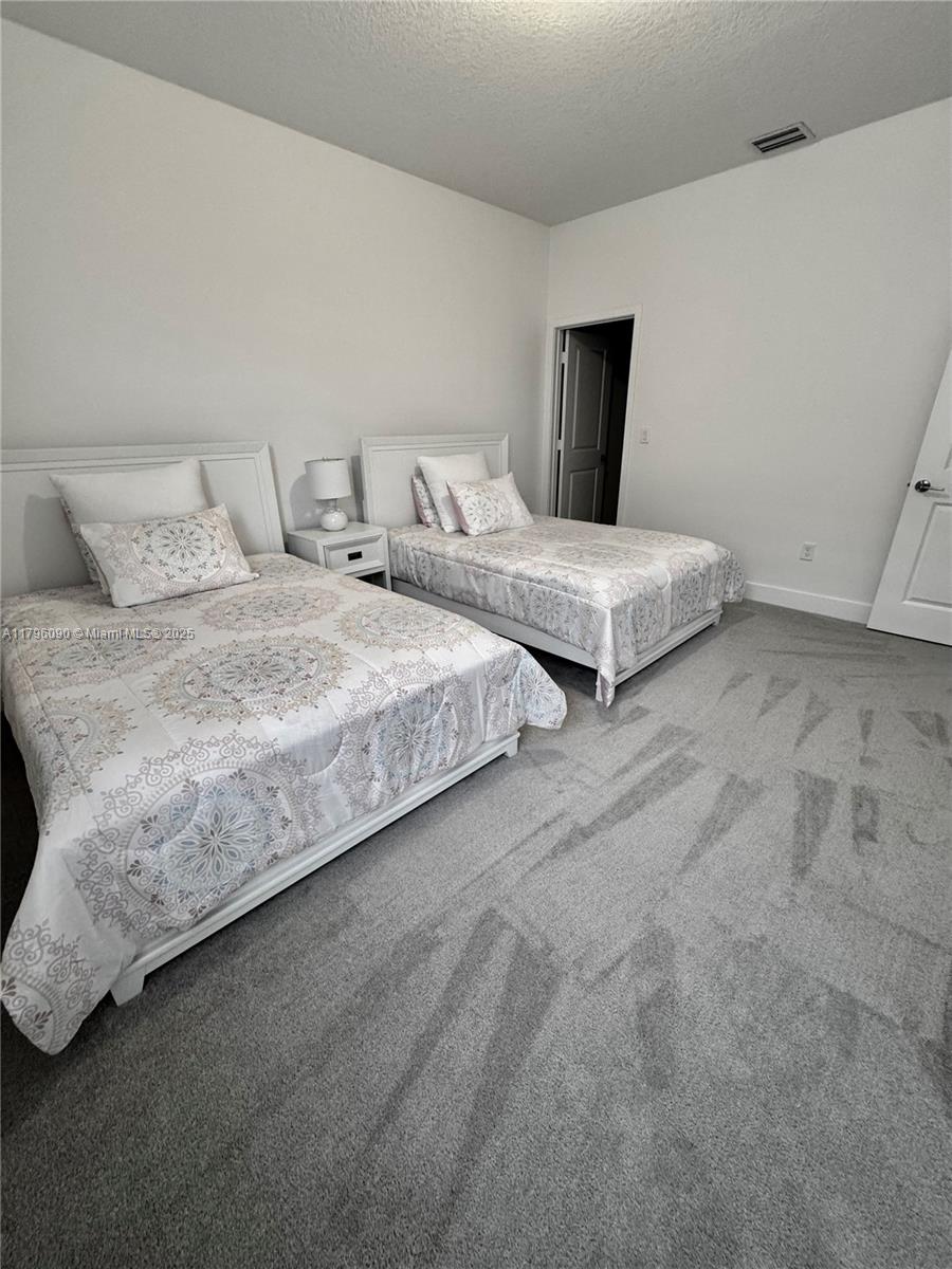 4409 Southwest 173rd Avenue Miramar, FL 33029 - Photo 30 of 38 a bedroom with two beds and painting on the wall