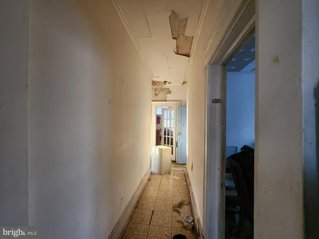 a view of a hallway with wooden floor and a bathroom