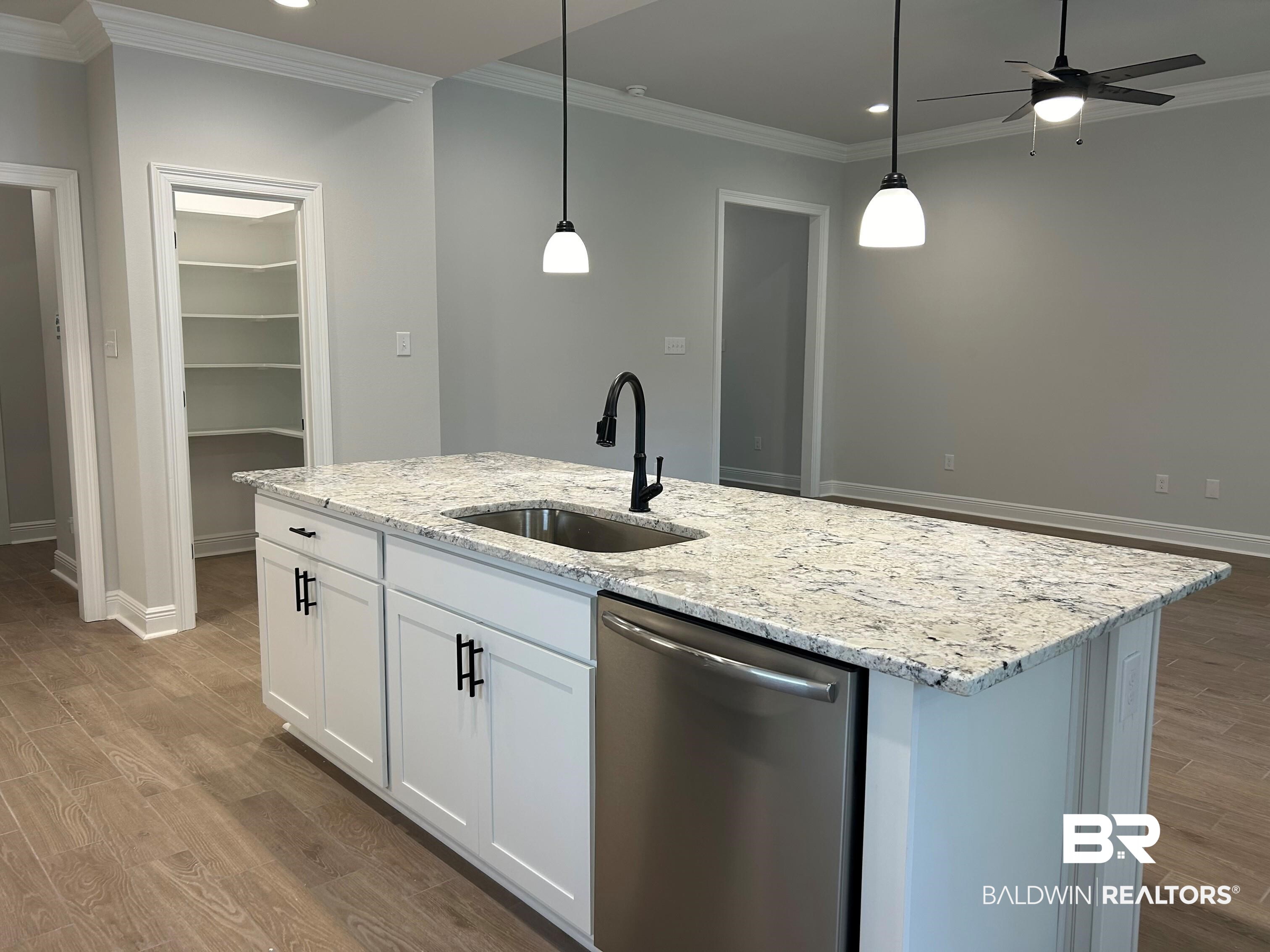 860 Sumter Loop Foley, AL 36535 - Photo 7 of 26 Kitchen with an island with sink, hanging light fixtures, sink, stainless steel dishwasher, and white cabinetry