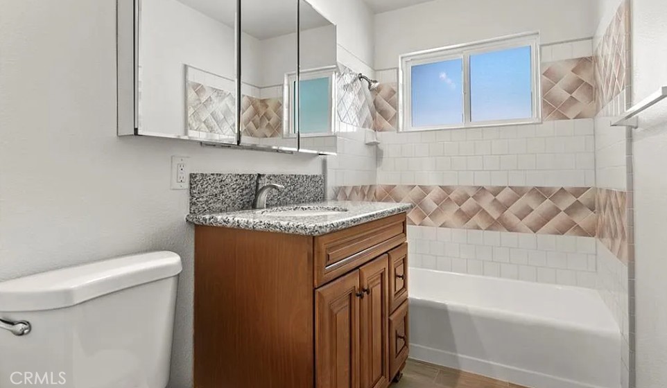 45122 Date Lancaster, CA 93534 - Photo 5 of 9 a bathroom with a granite countertop sink a toilet and bathtub