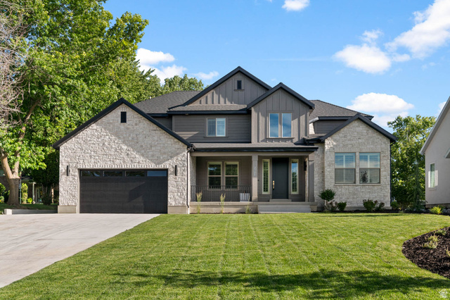2724 Mt Jordan Road Sandy, UT 84092 - Photo 2 of 39 Modern farmhouse-style exterior featuring a striking combination of light-colored stone veneer and dark-toned vertical siding