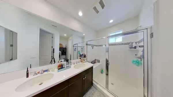 a bathroom with a double vanity sink mirror double and shower