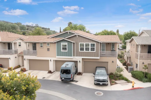 a view of a white house with a swimming pool and furniture