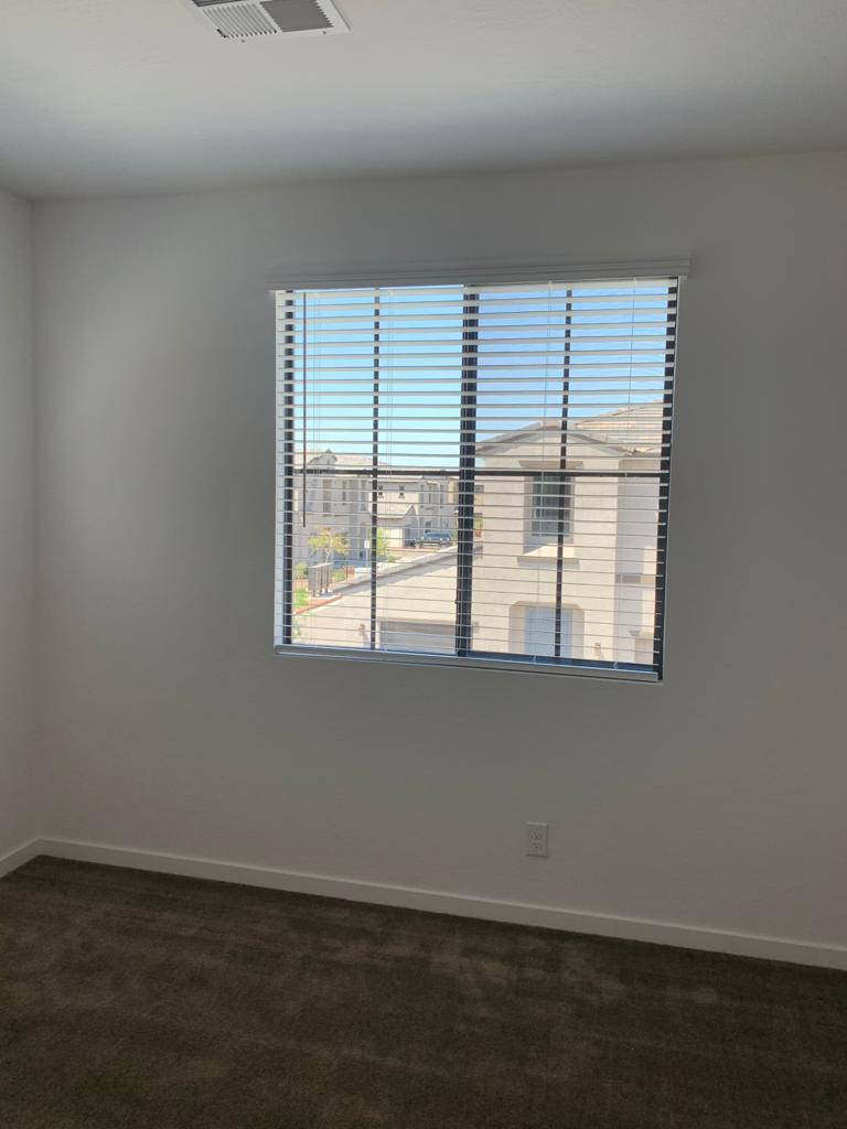 3900 East Baseline Road, Unit 118 Phoenix, AZ 85042 - Photo 10 of 32 a view of an empty room with wooden floor and a window