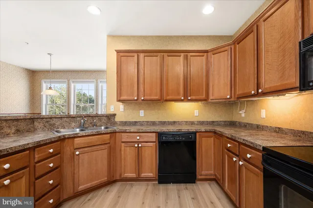a kitchen with stainless steel appliances granite countertop a sink and cabinets with wooden floor