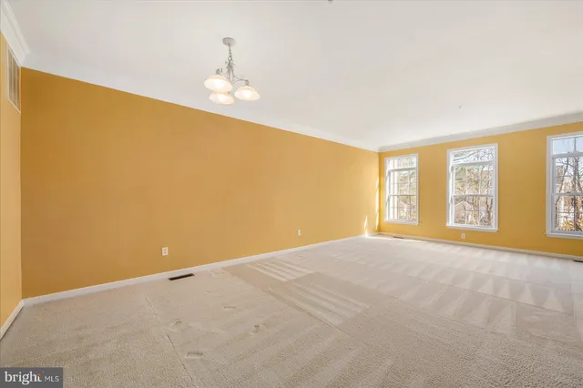 a view of a big room with windows and chandelier fan