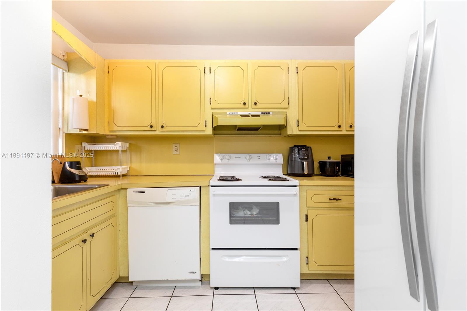 1630 West 46th Street, Unit 514B Hialeah, FL 33012 - Photo 11 of 26 a kitchen with a stove a sink and a refrigerator