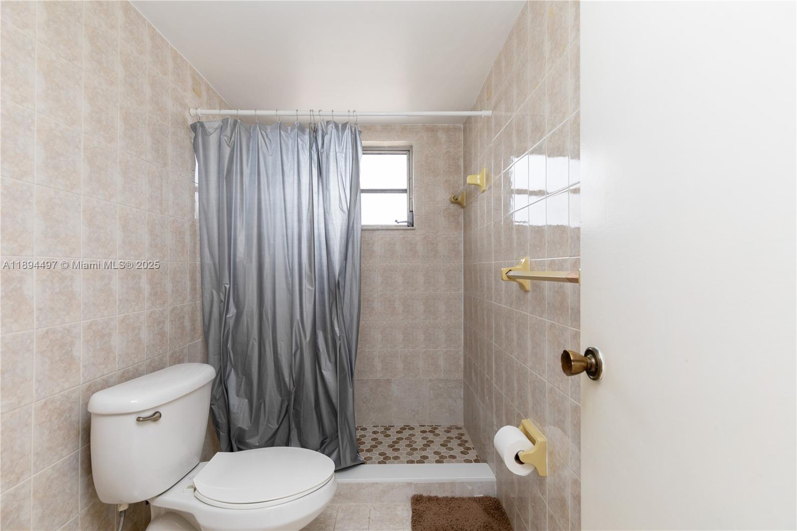 1630 West 46th Street, Unit 514B Hialeah, FL 33012 - Photo 17 of 26 a white toilet sitting next to a shower curtain