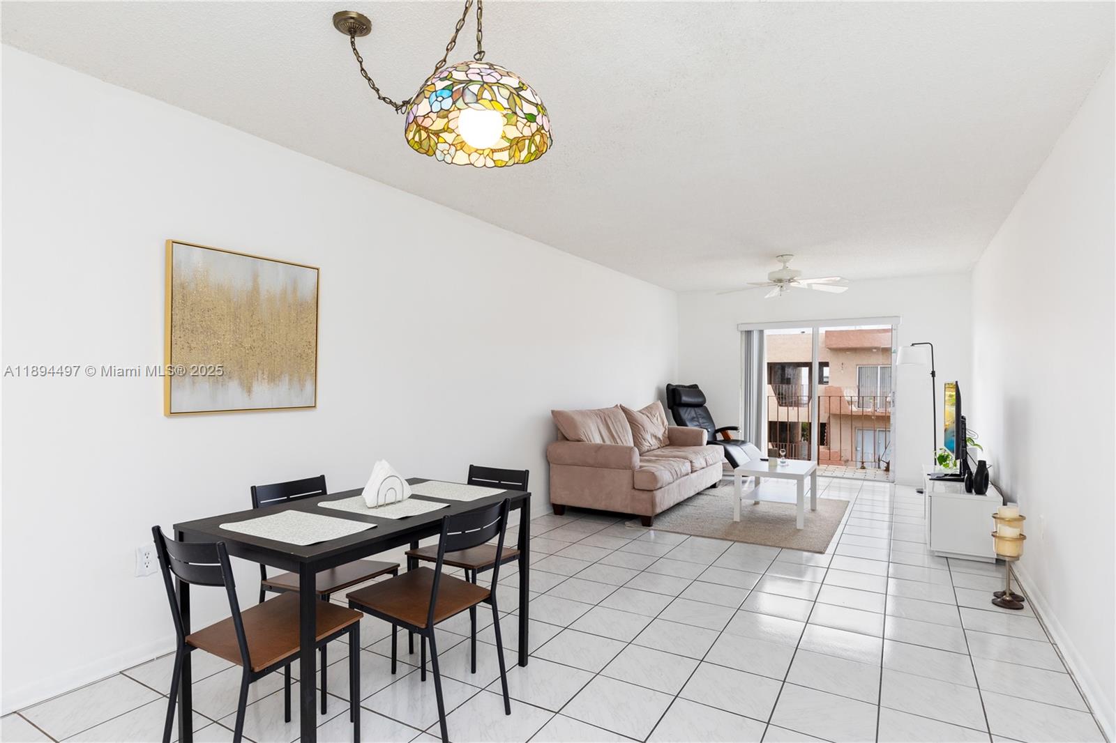 1630 West 46th Street, Unit 514B Hialeah, FL 33012 - Photo 7 of 26 a living room with furniture and a dining table with painted walls
