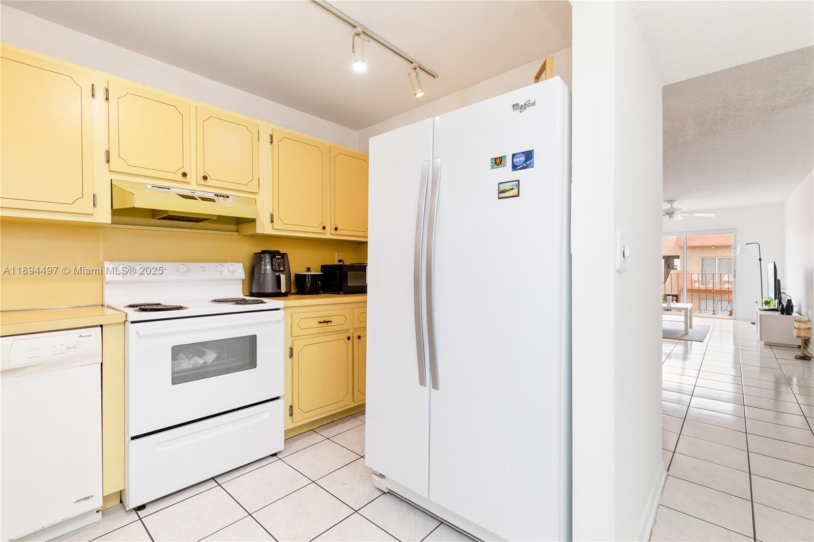 1630 West 46th Street, Unit 514B Hialeah, FL 33012 - Photo 10 of 26 a kitchen with a refrigerator a stove top oven and cabinets