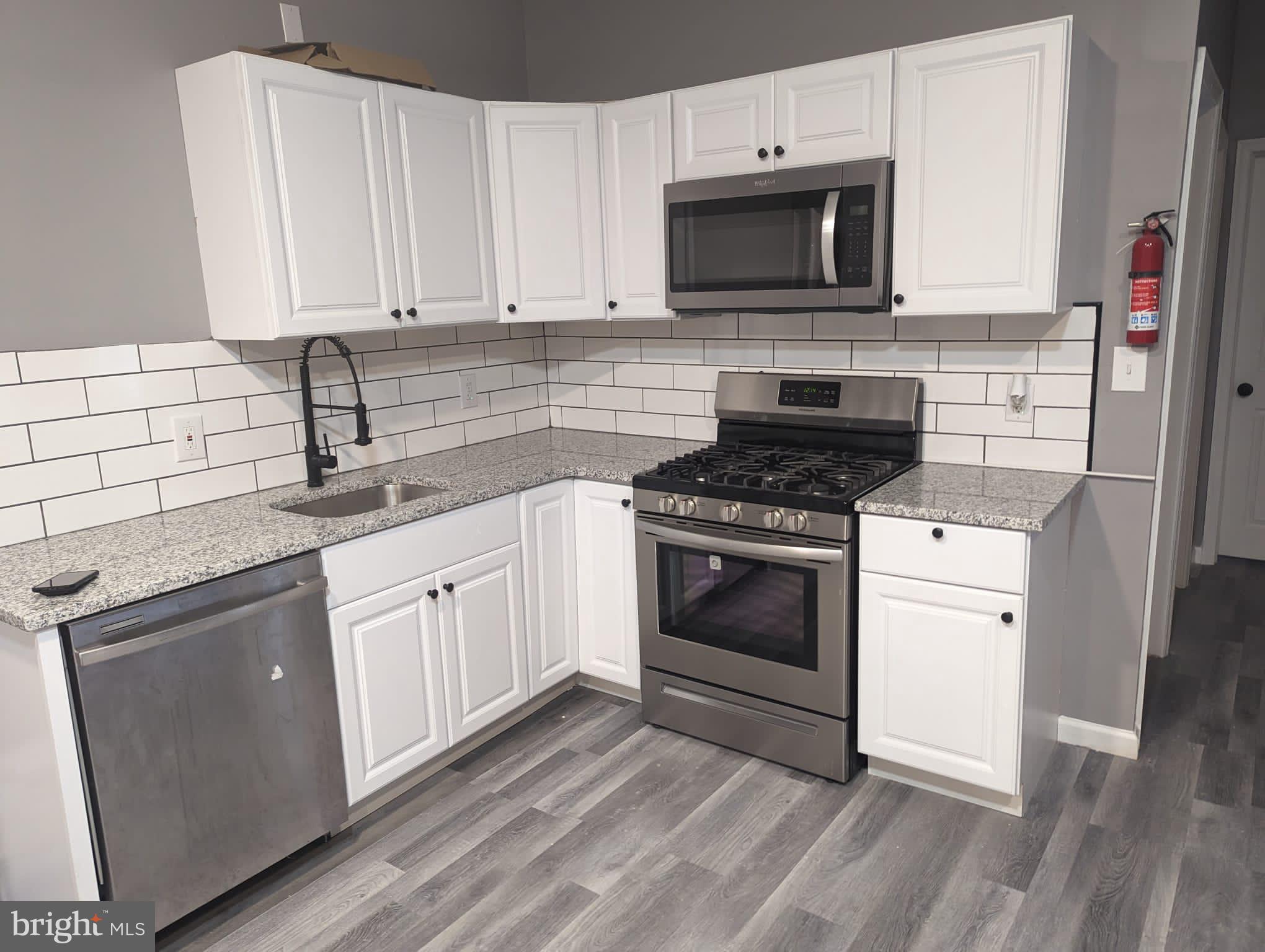 a kitchen with cabinets stainless steel appliances and sink
