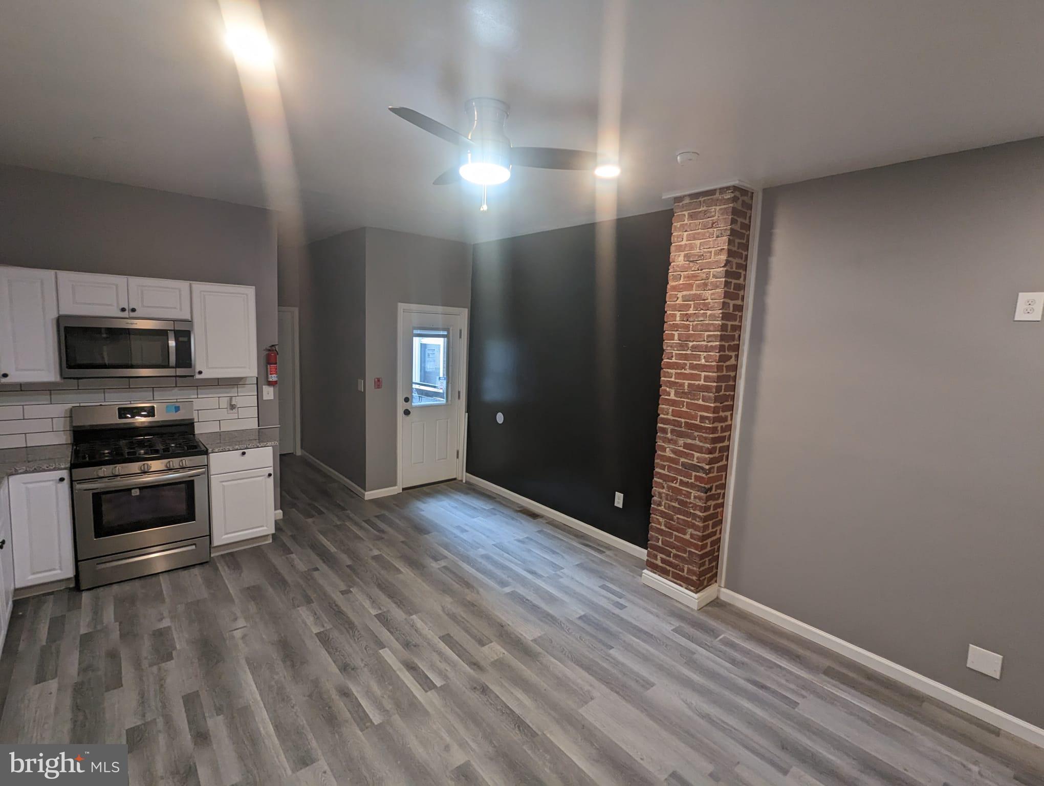 883 North Preston Street Philadelphia, PA 19104 - Photo 3 of 12 wooden floor in an empty room with a kitchen
