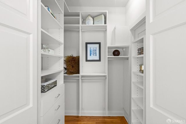 a view of walk in closet with clothes and shoes
