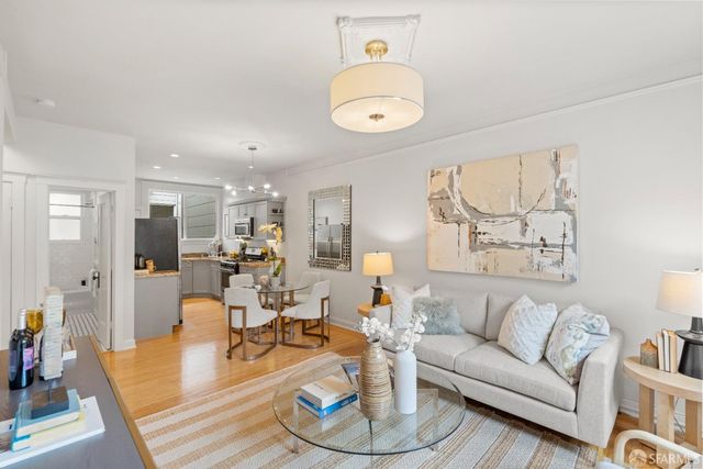 a living room with furniture kitchen view and a large window