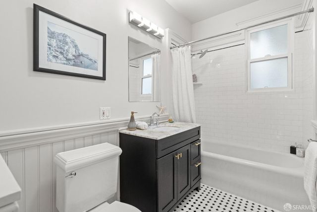 a bathroom with a sink a toilet a shower curtain and a bath tub