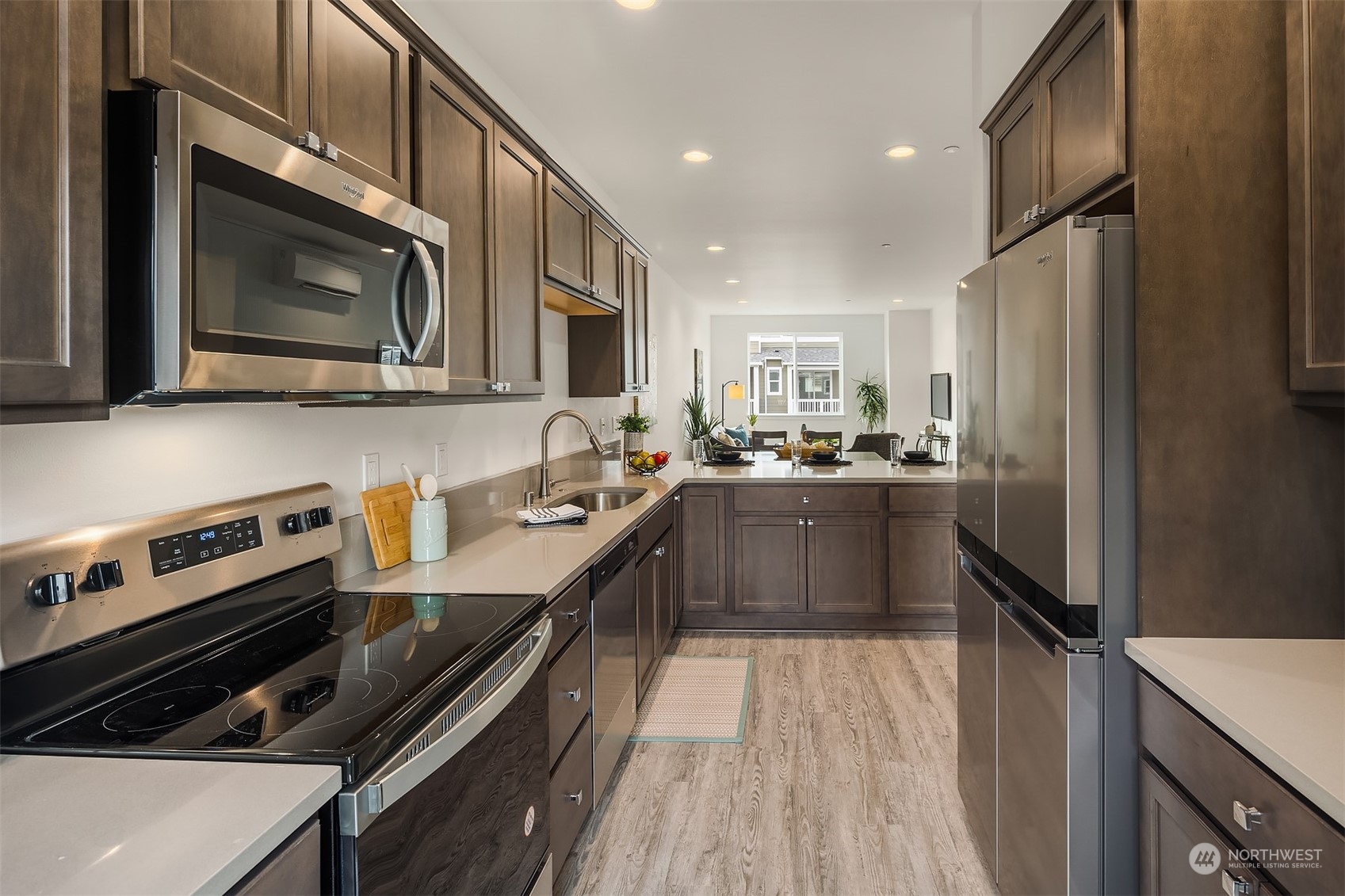 115 Southwest 181st Place, Unit C11 Normandy Park, WA 98166 - Photo 3 of 26 a kitchen with stainless steel appliances a stove a sink a microwave a refrigerator and cabinets