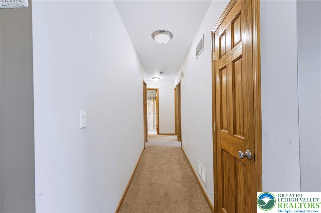6970 Silver Crest Road Nazareth, PA 18064 - Photo 23 of 35 Carpeted hallway leads to several rooms, illuminated by ceiling-mounted lighting.