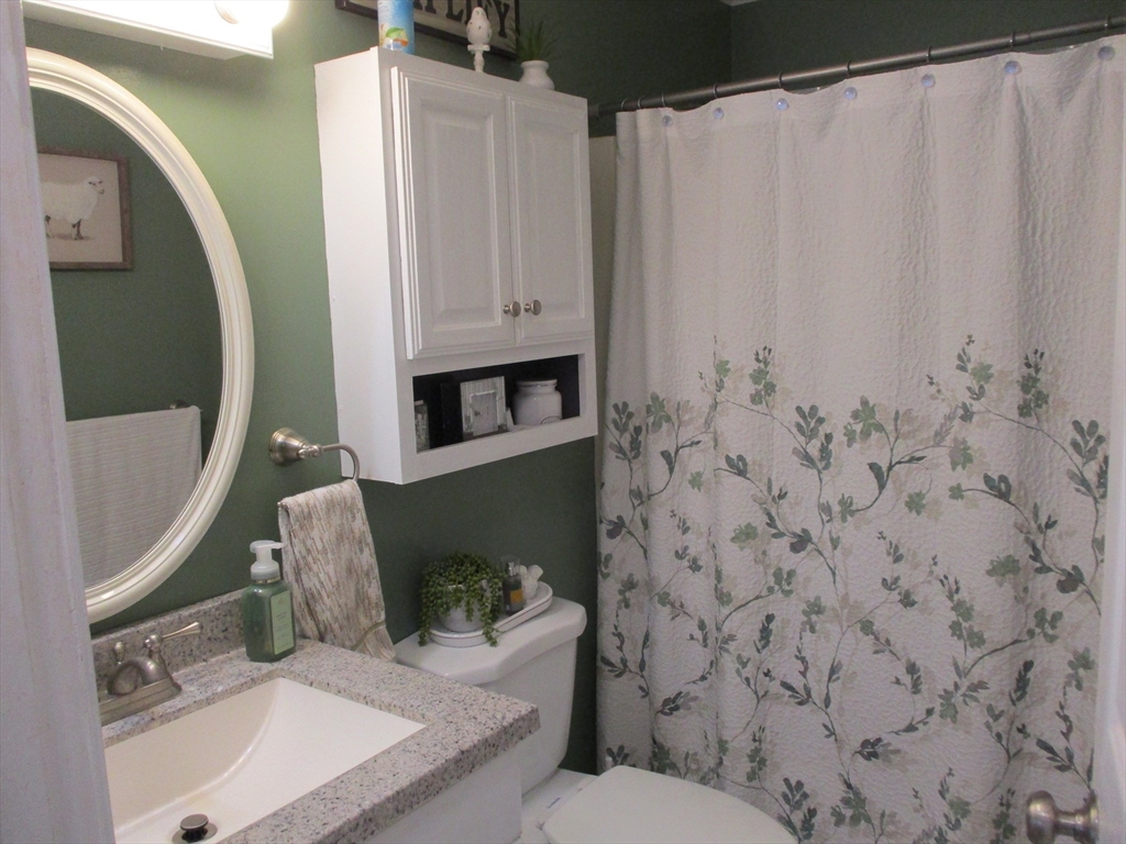 1475 Braley Road, Unit 21 New Bedford, MA 02745 - Photo 19 of 20 a bathroom with a sink a toilet and shower curtain