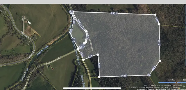 a view of a green field with wooden fence