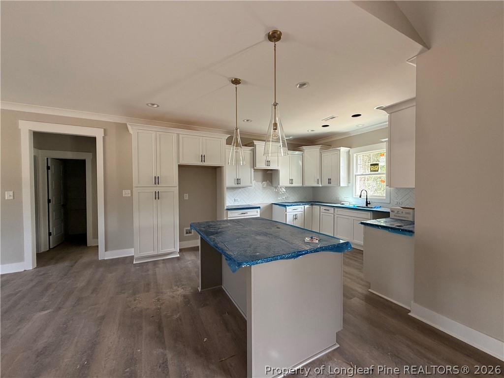 132 Ridge Stone Drive Autryville, NC 28318 - Photo 6 of 26 a kitchen with kitchen island a counter top space a sink and appliances