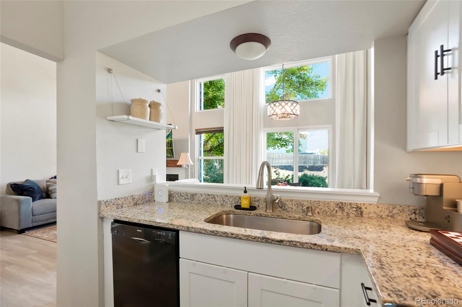 9191 Hickory Circle Highlands Ranch, CO 80126 - Photo 11 of 27 a kitchen with granite countertop a sink and a window