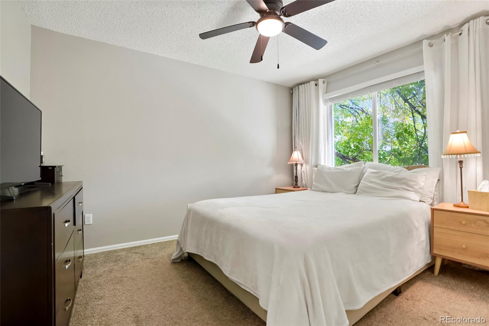 9191 Hickory Circle Highlands Ranch, CO 80126 - Photo 13 of 27 a bedroom with a bed and a chandelier