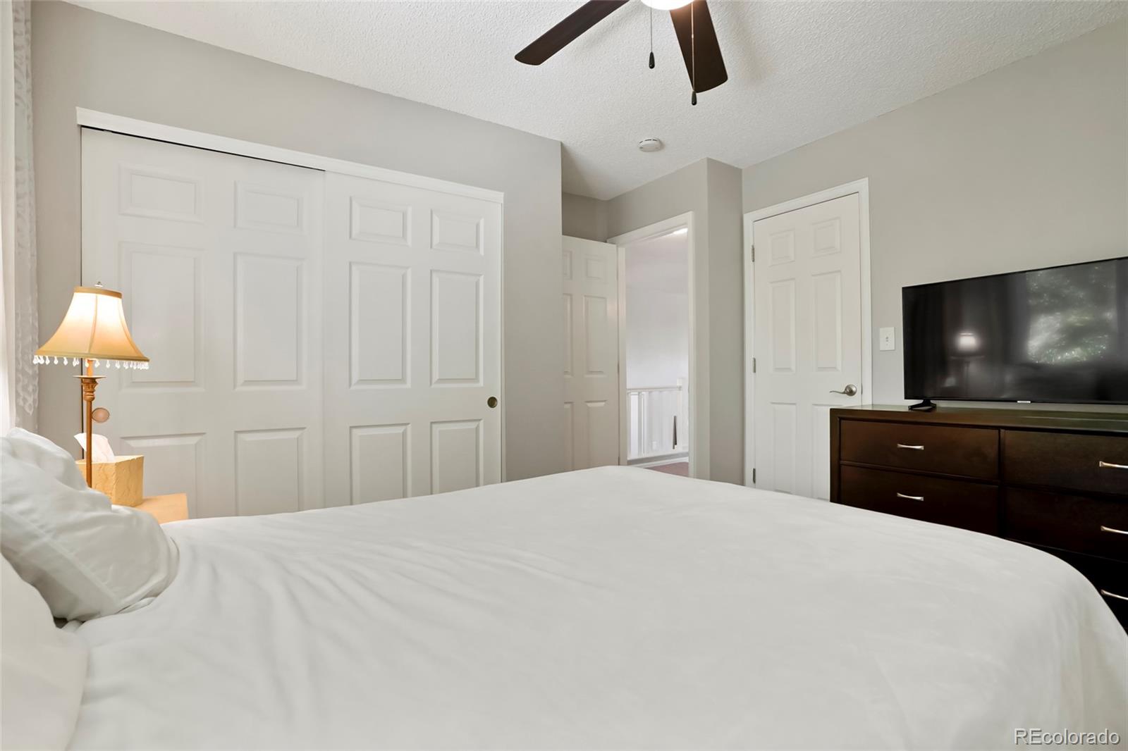 9191 Hickory Circle Highlands Ranch, CO 80126 - Photo 14 of 27 a bedroom with a bed and a flat screen tv