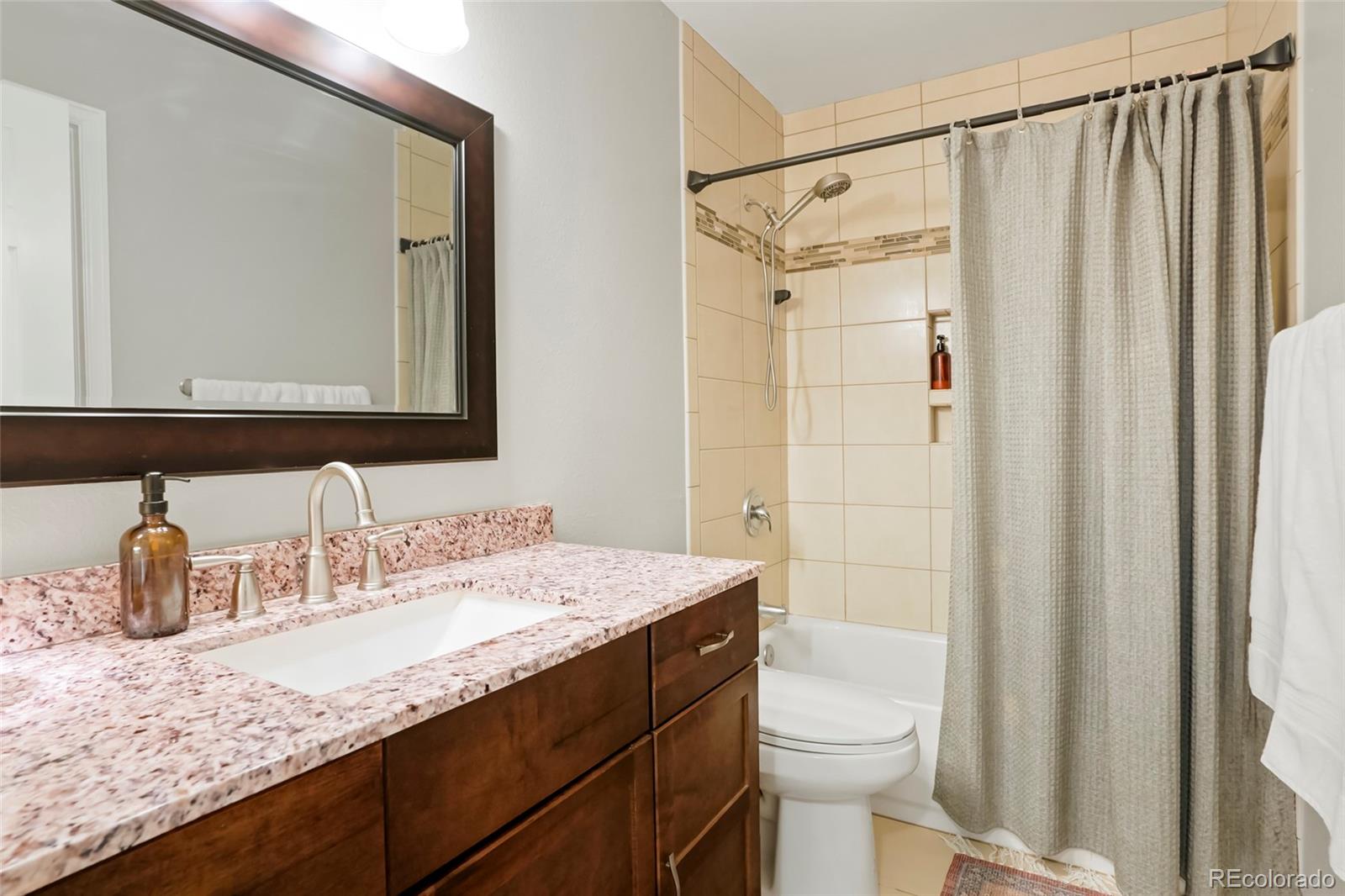 9191 Hickory Circle Highlands Ranch, CO 80126 - Photo 15 of 27 a bathroom with a granite countertop sink toilet and shower