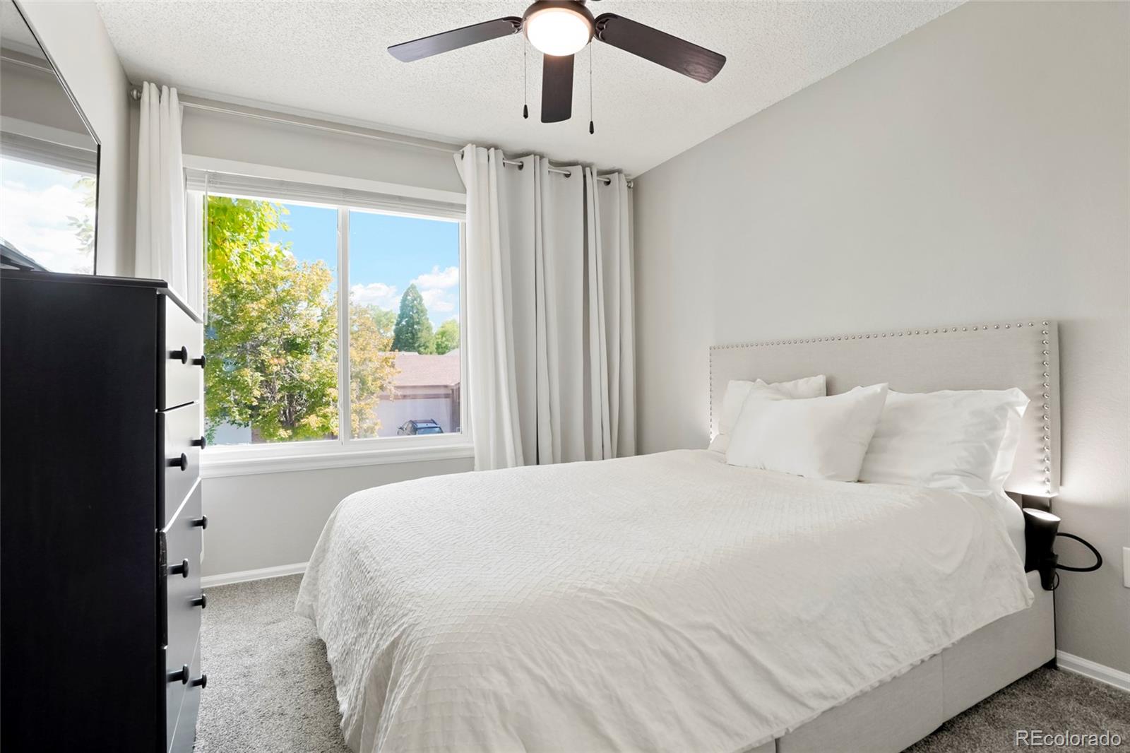 9191 Hickory Circle Highlands Ranch, CO 80126 - Photo 16 of 27 a large white bed in a bedroom next to a window