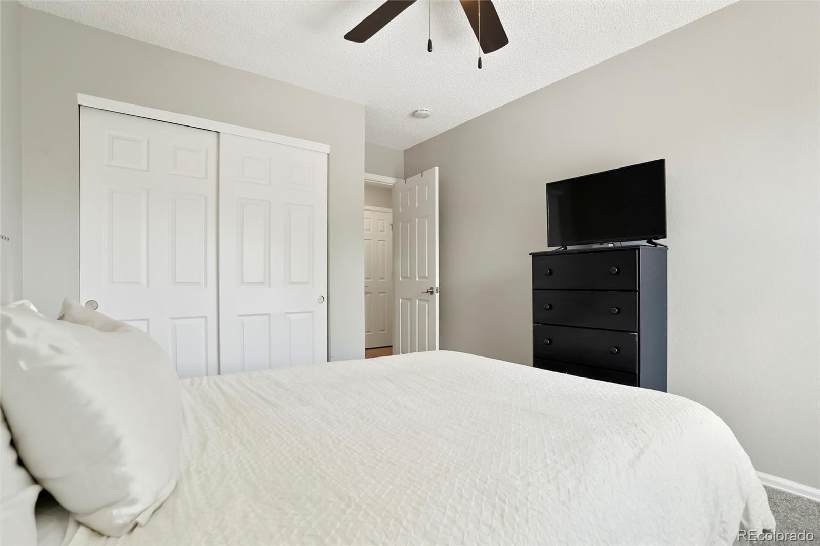 9191 Hickory Circle Highlands Ranch, CO 80126 - Photo 17 of 27 a bedroom with a bed and a television