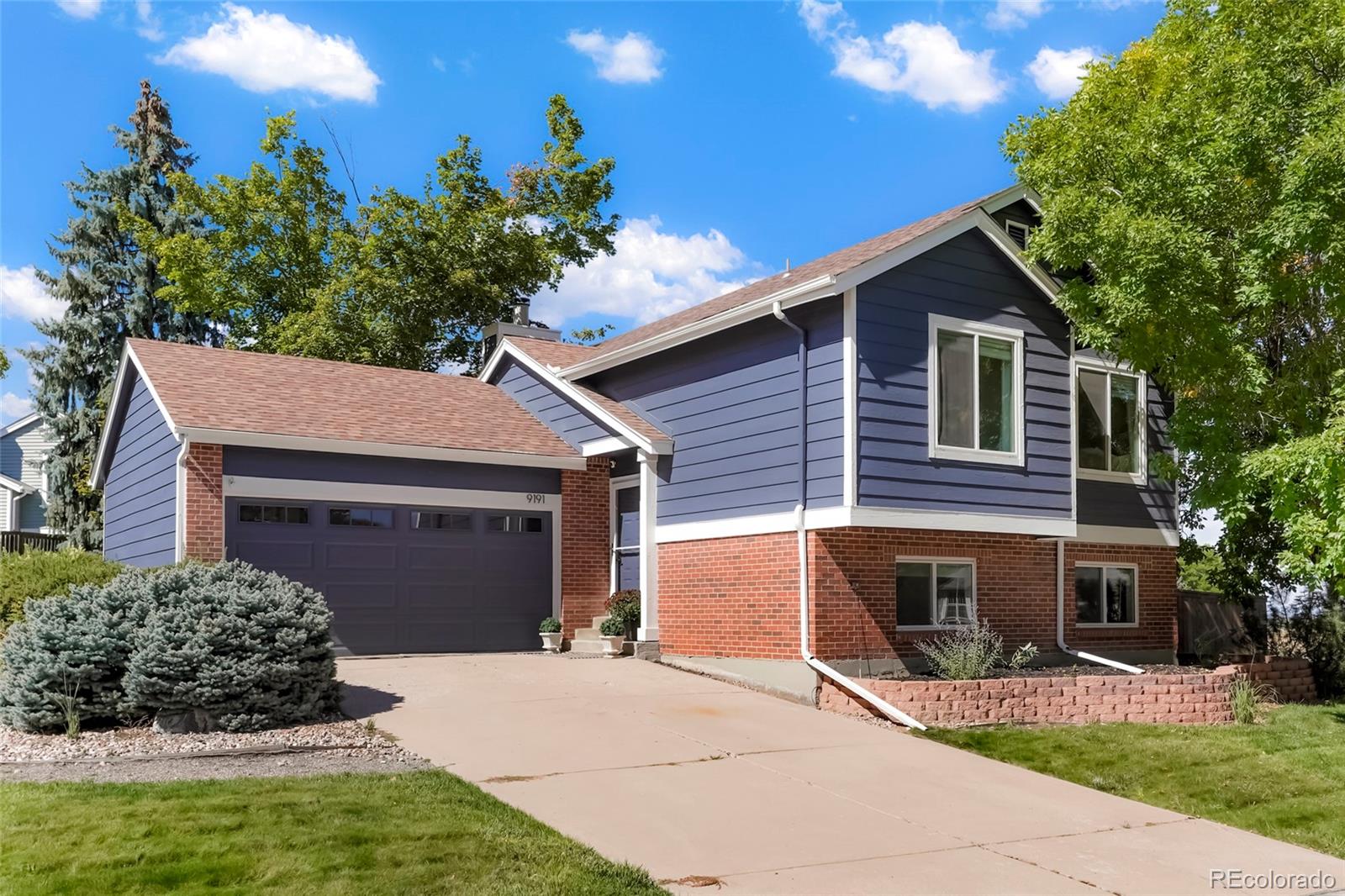 9191 Hickory Circle Highlands Ranch, CO 80126 - Photo 2 of 27 a front view of a house with a garden