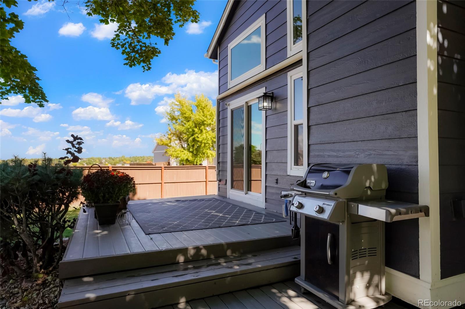 9191 Hickory Circle Highlands Ranch, CO 80126 - Photo 24 of 27 a view of a patio with table and chairs with wooden floor and fence