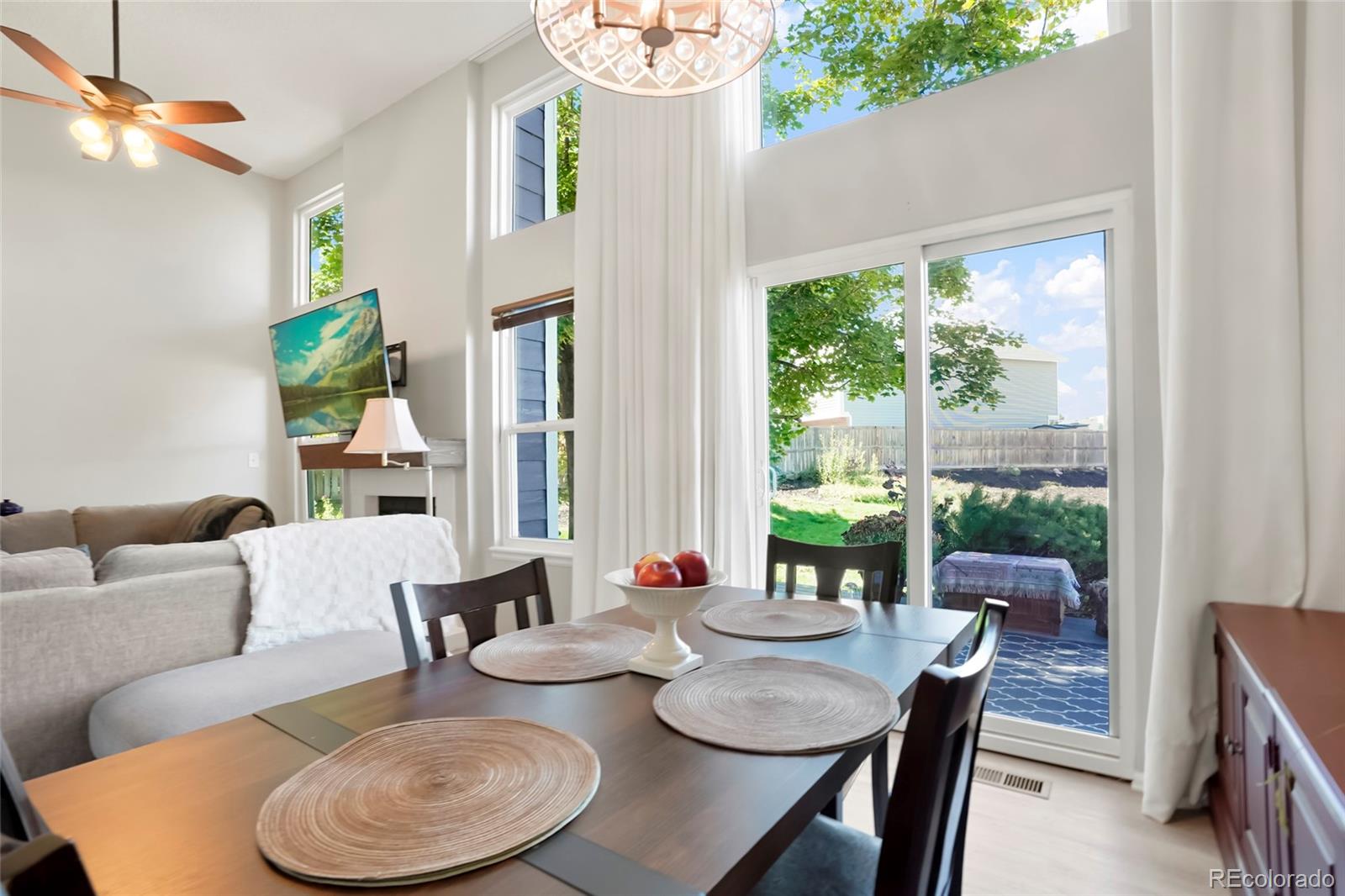 9191 Hickory Circle Highlands Ranch, CO 80126 - Photo 8 of 27 a dining room with furniture large windows and wooden floor
