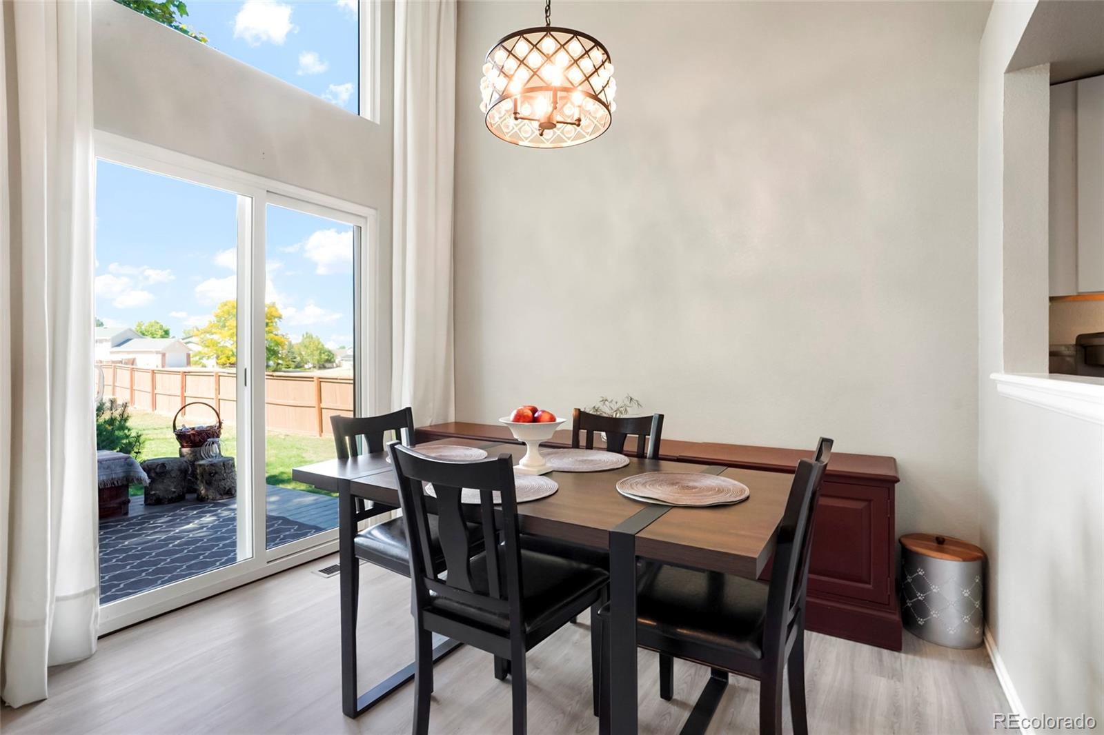 9191 Hickory Circle Highlands Ranch, CO 80126 - Photo 9 of 27 a view of a dining room with furniture wooden floor and a chandelier