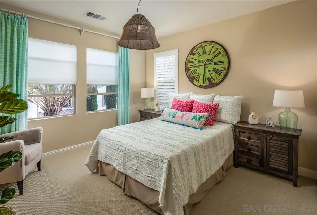 757 Blossom Road Encinitas, CA 92024 - Photo 18 of 25 a bedroom with a bed a window and a chandelier