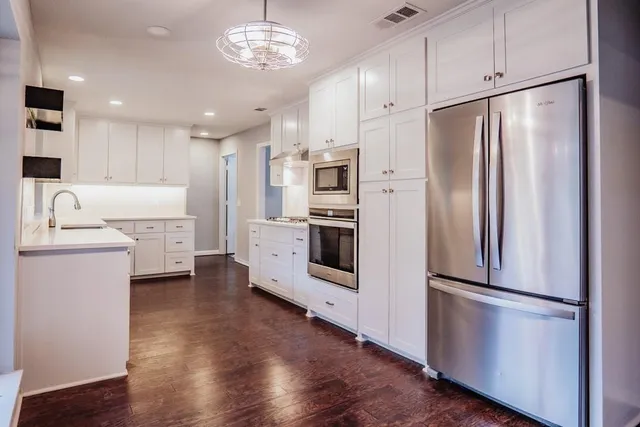 a kitchen with stainless steel appliances a refrigerator sink and microwave