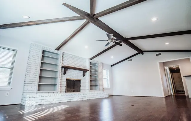 a view of an empty room with a fireplace and a window
