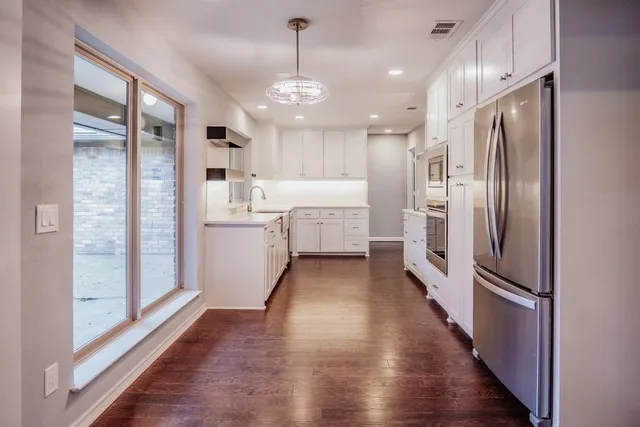 a kitchen with white cabinets and stainless steel appliances