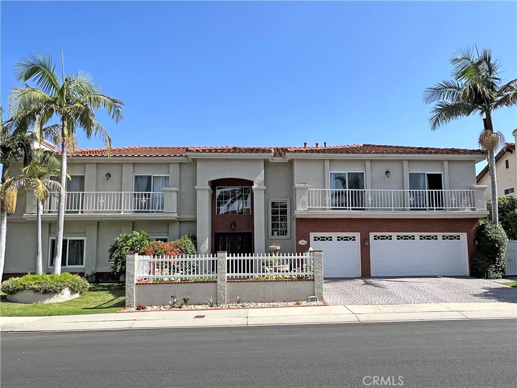 a front view of a house with a garden and tree