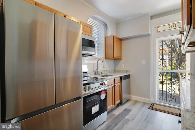 a kitchen with stainless steel appliances granite countertop a stove a sink and a refrigerator