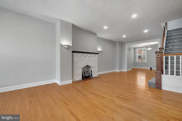 a view of empty room with wooden floor and fireplace