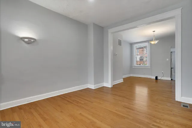 a view of empty room with wooden floor