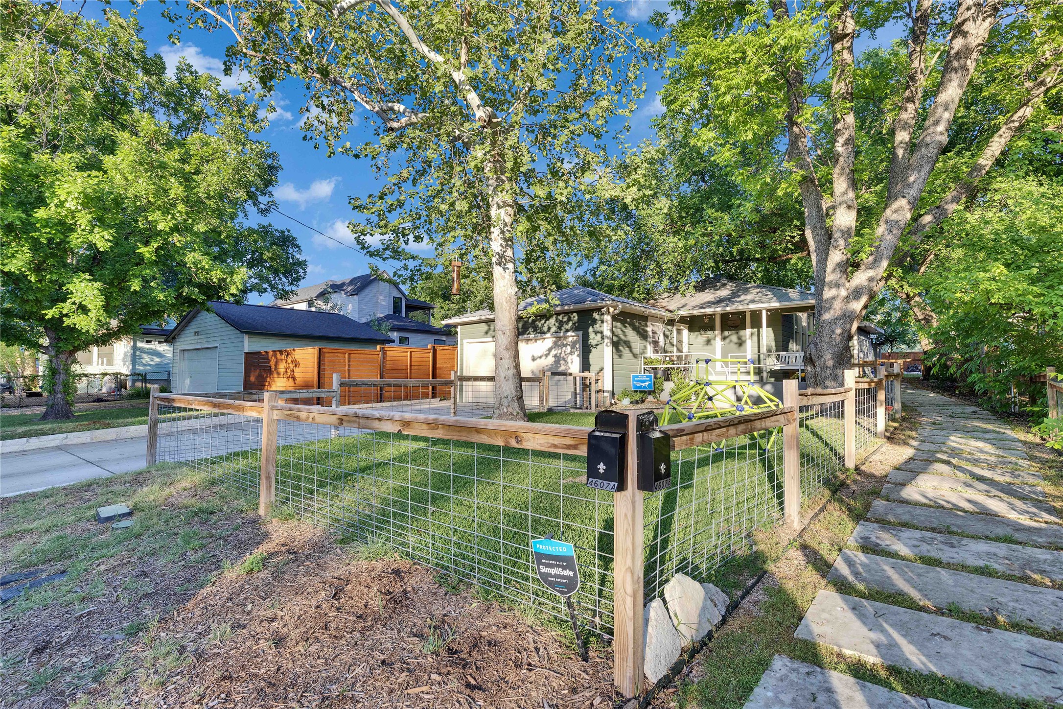 4607 Evans Avenue, Unit B Austin, TX 78751 - Photo 1 of 34 Charming residence featuring a partial wire fence, stone path, a detached garage, and mature trees providing natural shade