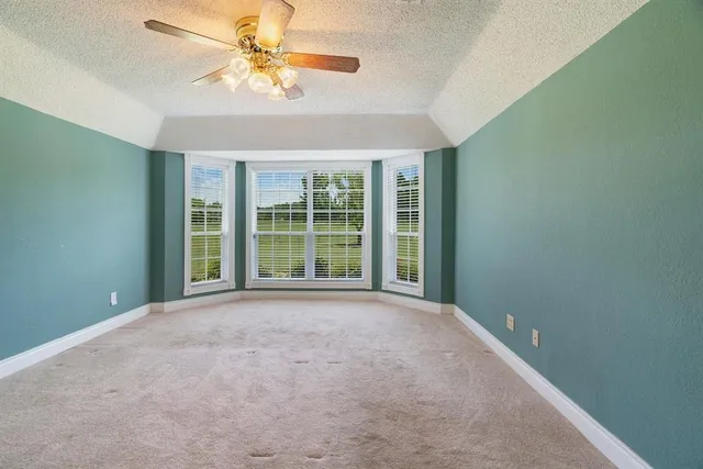 a view of a room with windows and ceiling fan