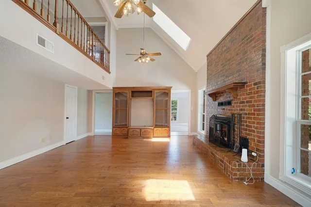 a view of empty room with fireplace and wooden floor