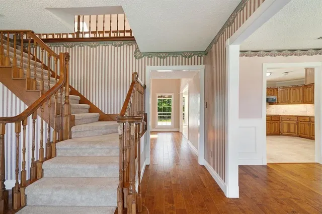 a view of a hallway with wooden floor and staircase